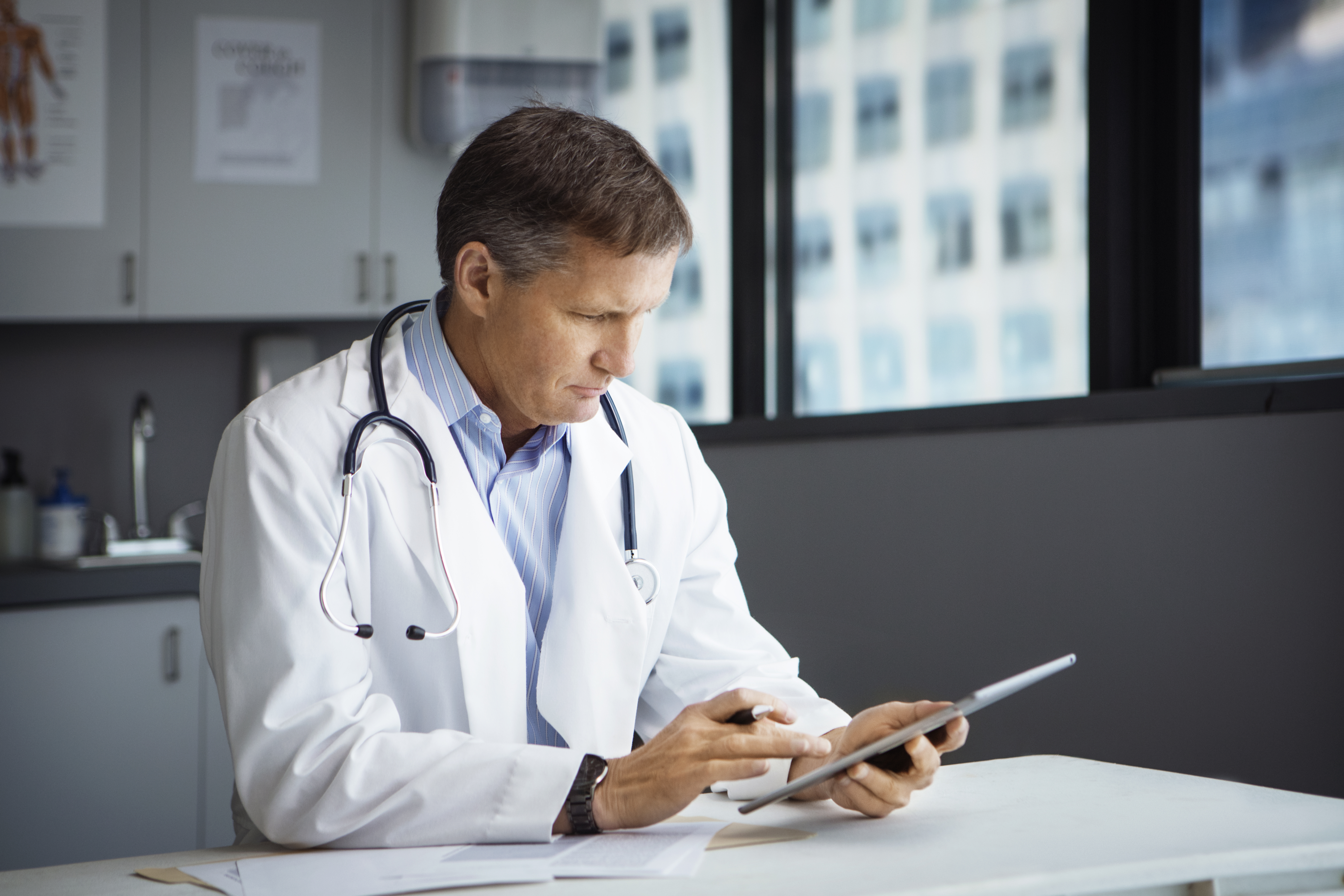 Male doctor using tablet computer in clinic