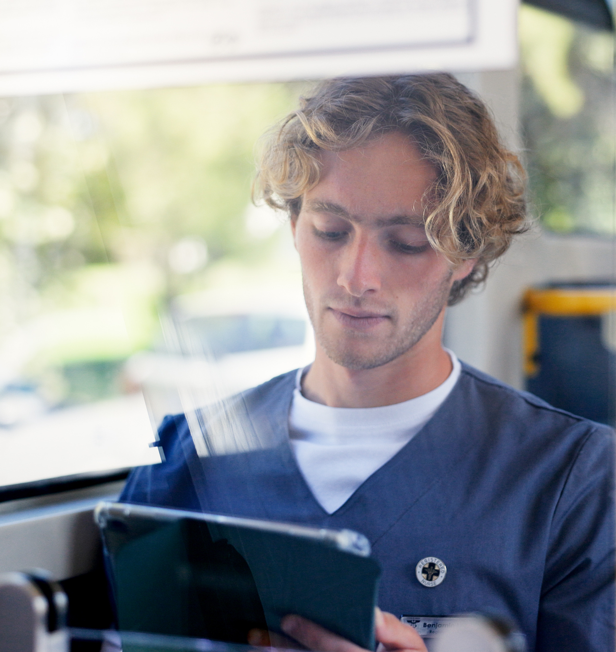 Male nurse on the bus with phone