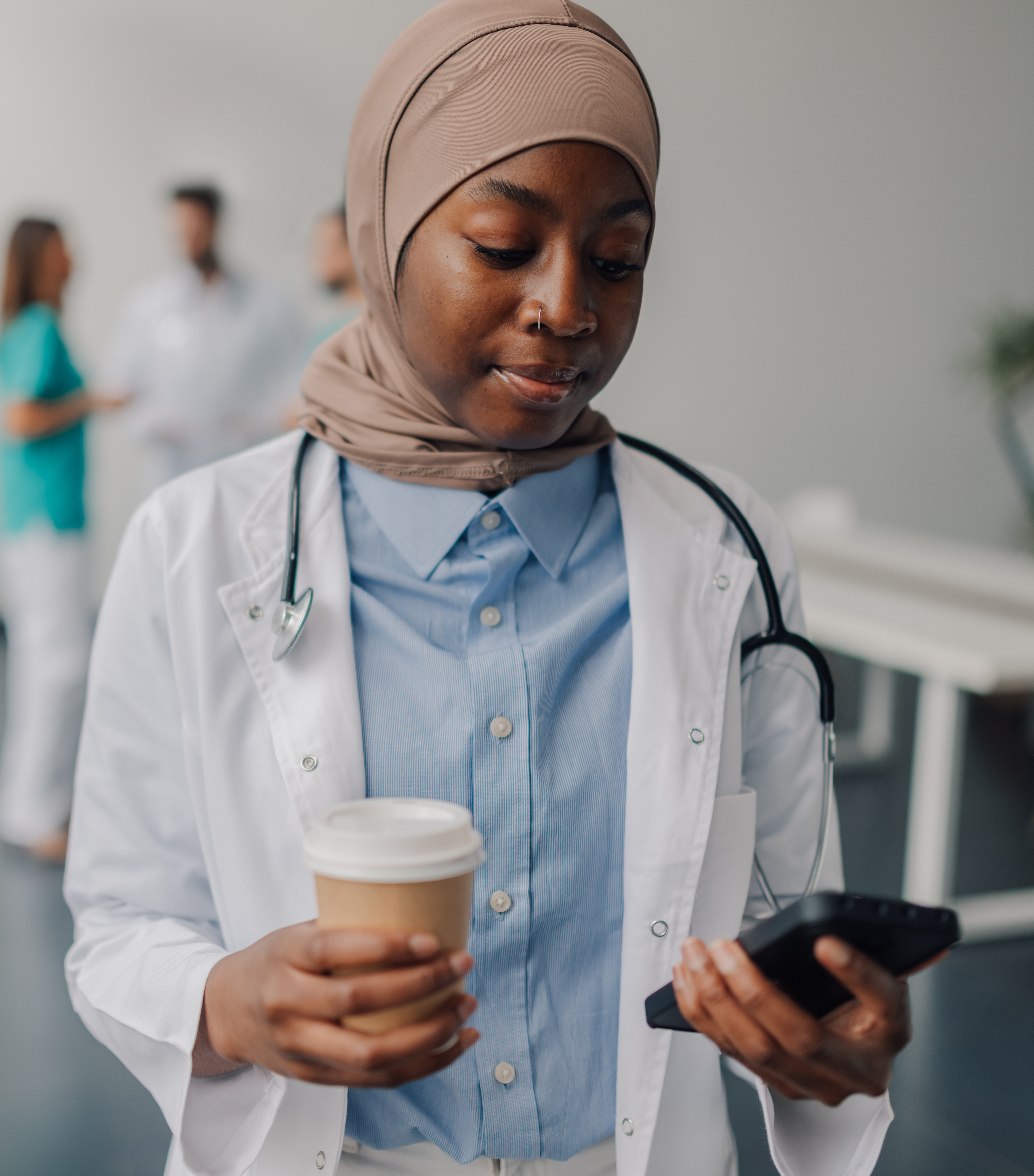 Muslim doctor wearing hijab using phone
